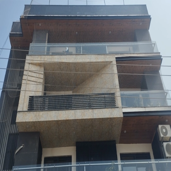 Modern building exterior with balconies and mesh netting details.